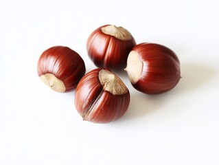 Close-up of four ripe, brown nuts on a white background. Healthy food, snack