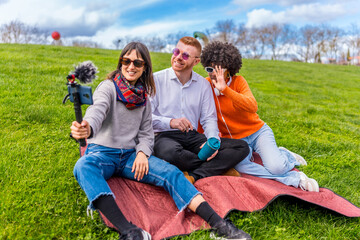 Content creators filming video blog in park using smartphone and external microphone