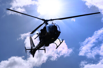 Silhouette of a combat helicopter in the sky, gazelle seen from underneath, air transportation