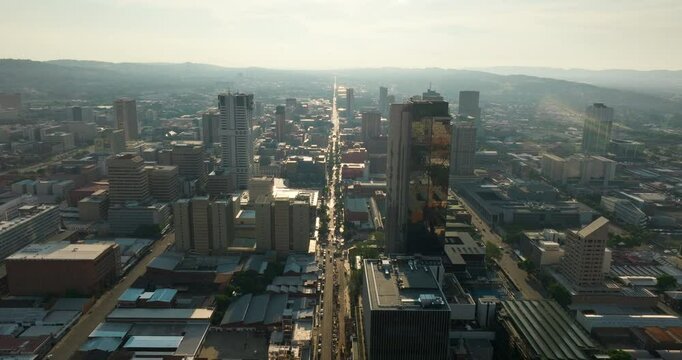 Scenic Aerial view of Pretoria Downtown Skyline with main arterial street in urban landscape. Perfect for cityscape and travel visuals. 4K drone panning shot of administrative capital of South Africa