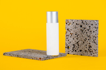 Cosmetic product in tube, bottle, lotion or serum with stylish props on yellow background. 