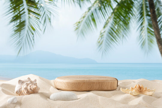 Wood podium on tropical sand beach with blurred blue sea, sky and palm tree leaves background