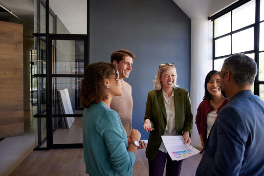 Happy multiethnic business team talking together in office lobby