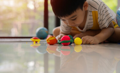 A Southeast Asian male toddler imagination of planets and space with child's play clay.