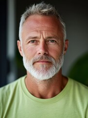 Obraz premium authentic portrait of attractive 50 years old European man in light green t-shirt at home, family man