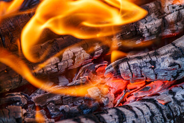 Red hot charcoal and a flame of fire.Close-up of fire, glowing charcoal and hot embers. The texture...