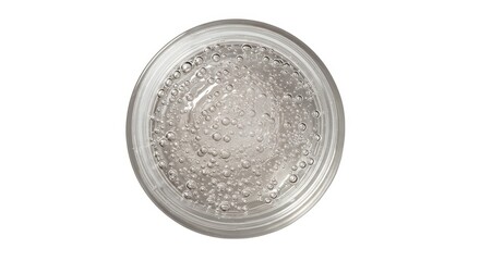 Close up of a clear glass filled with a bubbly liquid against a plain white background from above view