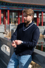Caucasian man enjoys stroll in Chinatown amidst vibrant architecture