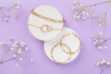 Elegant golden jewelry with decoration on color background, top view