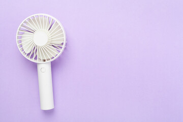 Mini electric fan on color background, top view
