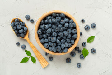 Bowl with fresh bright blueberries on concrete background,top view