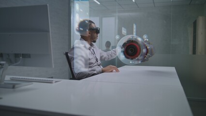 African American Engineer Uses Augmented Reality Headset to Visualize 3D Holographic Model of Renewable Energy Engine. Virtual Visualization of Design Software Based on Artificial Intelligence.