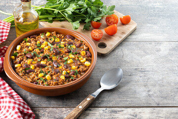 Traditional Mexican Chili con carne. Minced meat and vegetables stew in tomato sauce on wooden table