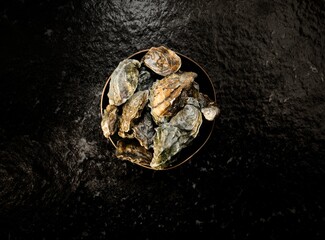 Freshly harvested local oysters are presented in a market, showcasing their natural beauty and...