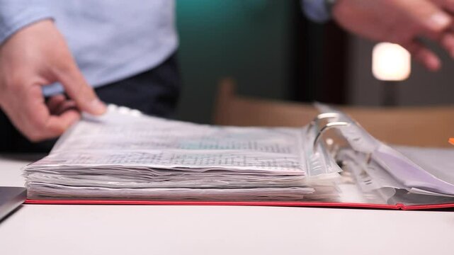 Office worker browsing through documents in a binder