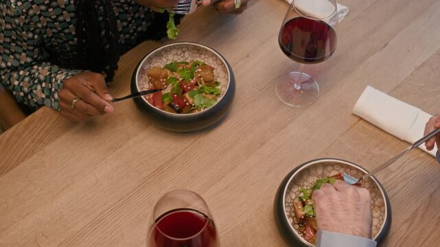 High angle view of bicultural couple having dinner with red wine in restaurant