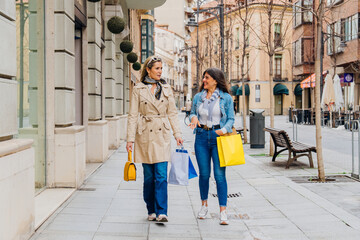 Two mature women walking and talking after shopping spree