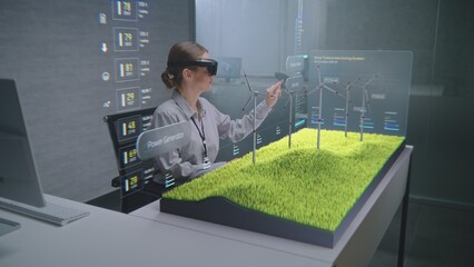 Futuristic Office: Female Engineer Uses Augmented Reality Headset to Visualize 3D Holographic Model of Wind Turbine on Wind Farm. Visualization of Artificial Intelligence Based Software Interface.