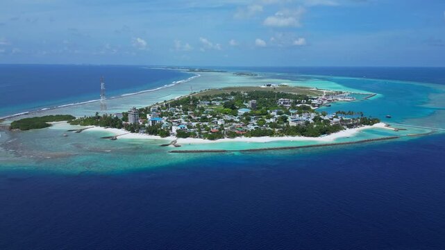 Hight angle view of Kaafu atoll at sunny day. Aerial view of Thulusdhoo island. Maldives. Tropical seascape of island in Indian Ocean under blue sky. High resolution video