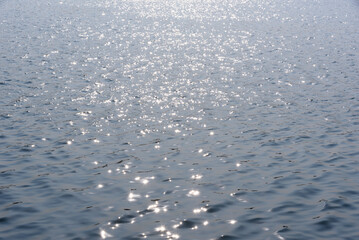 The sunlight shines on the river, and the surface of the water sparkles.