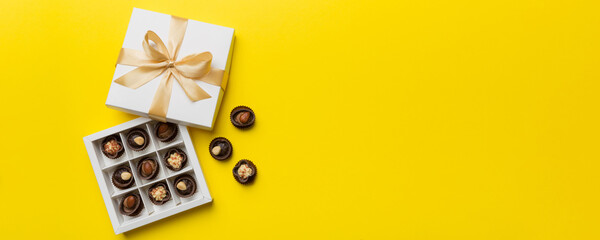 White box with chocolates candies and golden tape. top view with copy space