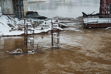 In the background, there is a bridge that spans across a flooded area, showcasing the extent of the...
