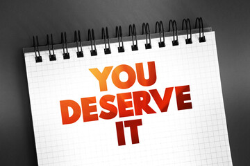 You Deserve It text on notepad, concept background