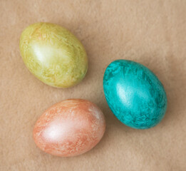 Dyed chicken eggs lies on a beige background.