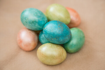 Dyed chicken eggs lies on a beige background.