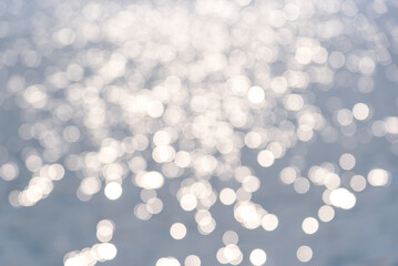 Circular light spots on the water surface. The river in bokeh. Dreamy blue background.