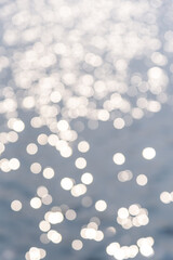 Circular light spots on the water surface. The river in bokeh. Dreamy blue background.
