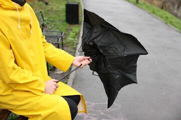 Man with broken umbrella under rain outdoors, closeup