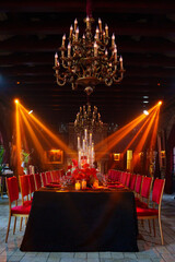 Spotlights in the banquet hall of a dark restaurant.
