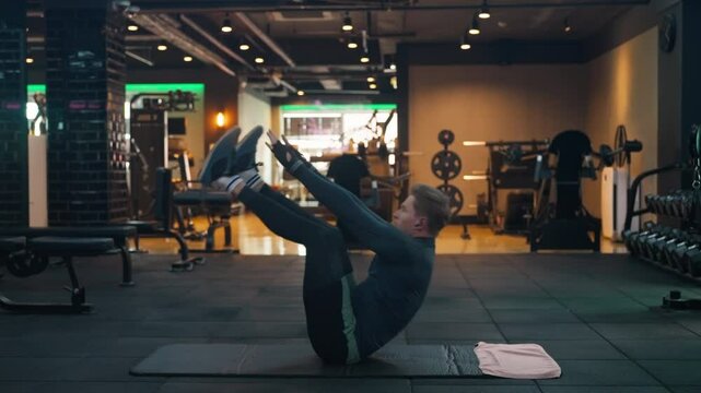 Caucasian Man Doing V-Ups Abs and Obliques Workout in Modern Gym