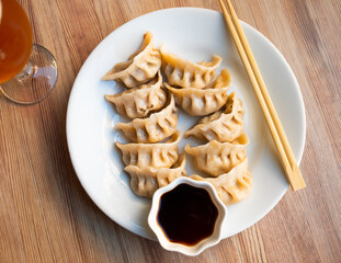 Japanese dish - dumplings gyoza with soy sauce on round plate. High quality photo