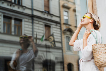 Happy woman wearing stylish outfit exploring of european old town. Travel Vacation Europe.