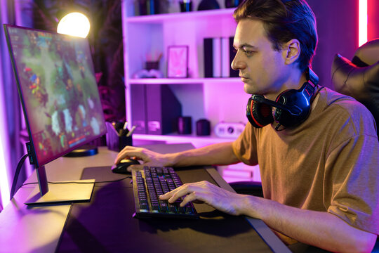 Host channel concentrated smart gaming streamer playing the fighting Moba on computer screen with muptiplayers or single at battle arena . Esport live streaming at neon digital light room. Pecuniary.