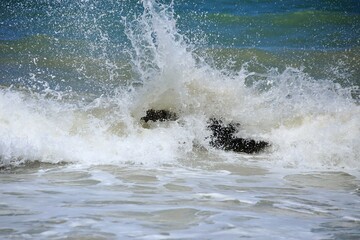 Strong water splitting on air, white foam by waves splashing on rock near the beach. Tabatinga beach, near Joao Pessoa city, Paraiba state, Brazil norheast