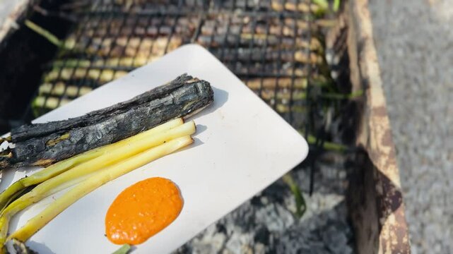 Plate of grilled cal&ccedil;ots served with traditional romesco sauce.