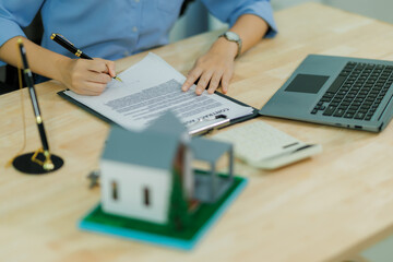 Fototapeta premium A female agent showcases the property and walks the client through the insurance cost calculation in an effort to sell a home insurance policy.