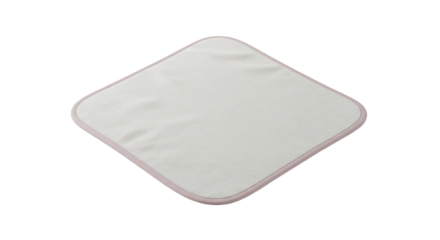 A white square cloth with a pink border is centered on a black background in a studio setting