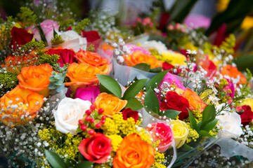 Colorful roses and baby's breath create a vibrant bouquet.