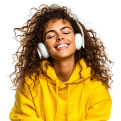 Happy young woman in yellow hoodie smiling with closed eyes, enjoying music via wireless headphones isolated on transparent or white background