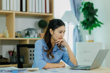 A young office woman appears frustrated as she struggles to reconcile the mismatched figures in the...