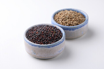 Indian Spices called Cumin Seeds and Mustard Seeds in bowls isolated on white background 