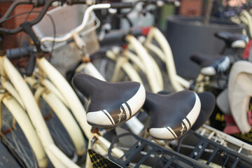 Obraz premium close-up view of bicycle handlebars at a bike-sharing station. The image highlights the details of the bicycle's design, showing the handlebars, grips, and lights. The background features a modern