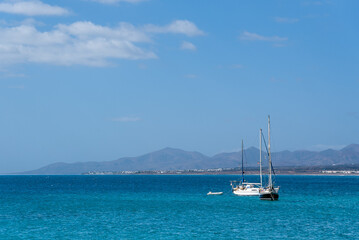 Yachts in the sea against distant shore