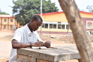 Obraz premium close up of an handsome african student writing his note