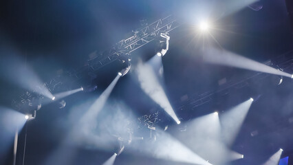 Professional lighting equipment illuminating stage with beams of light during a show