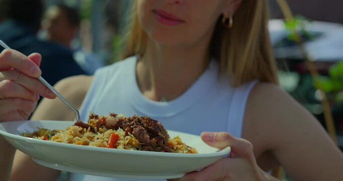 Enjoying a Plate of Traditional Uzbek Plov Outdoors
